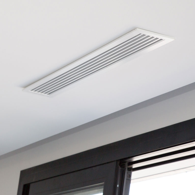 grille de soufflage de climatisation gainable encastree au plafond pres d une fenetre dans un logement a Villeurbanne