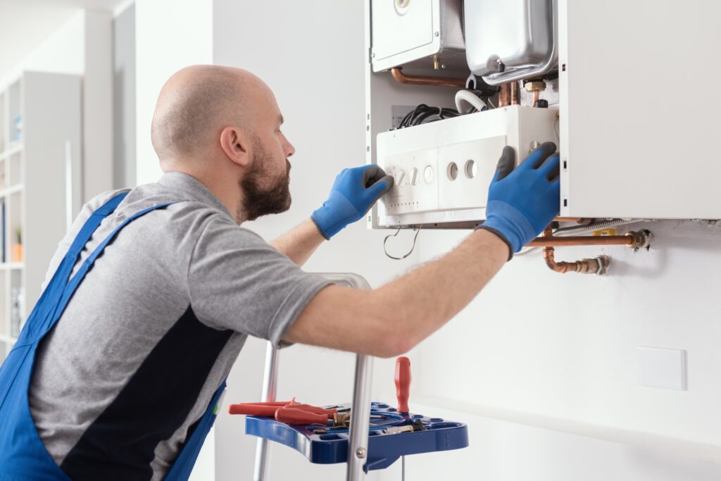 Climatisation chauffage et plomberie à Lyon Ankial - professional engineer servicing a boiler at home Ankial Ankial https://climatisation-lyon.com plombier lyon plombier lyon