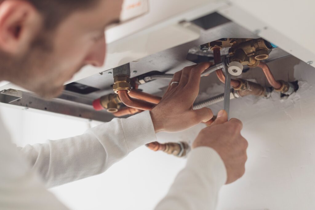 Climatisation chauffage et plomberie à Lyon Ankial - professional plumber checking a boiler Ankial Ankial https://climatisation-lyon.com climatisation lyon climatisation lyon,chauffagiste lyon,plomberie lyon