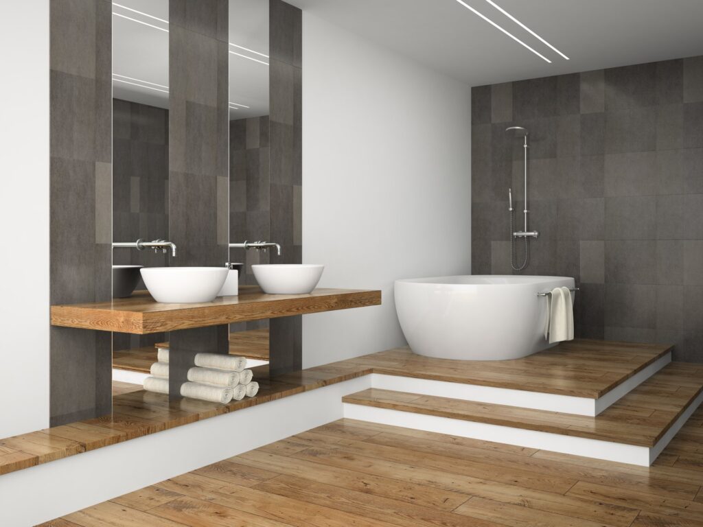 Salle de bain moderne avec baignoire îlot ovale et double vasque posée sur plan en bois, douche italienne carrelée gris foncé