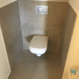 toilettes suspendues installees par notre plombier dans des wc carreles gris a Decines-Charpieu pres de Lyon